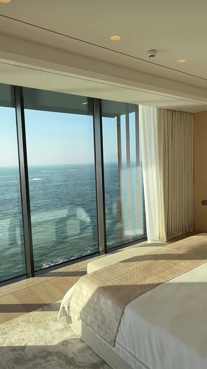 Motorized beige curtains and sheers on a wide window in a Dubai home