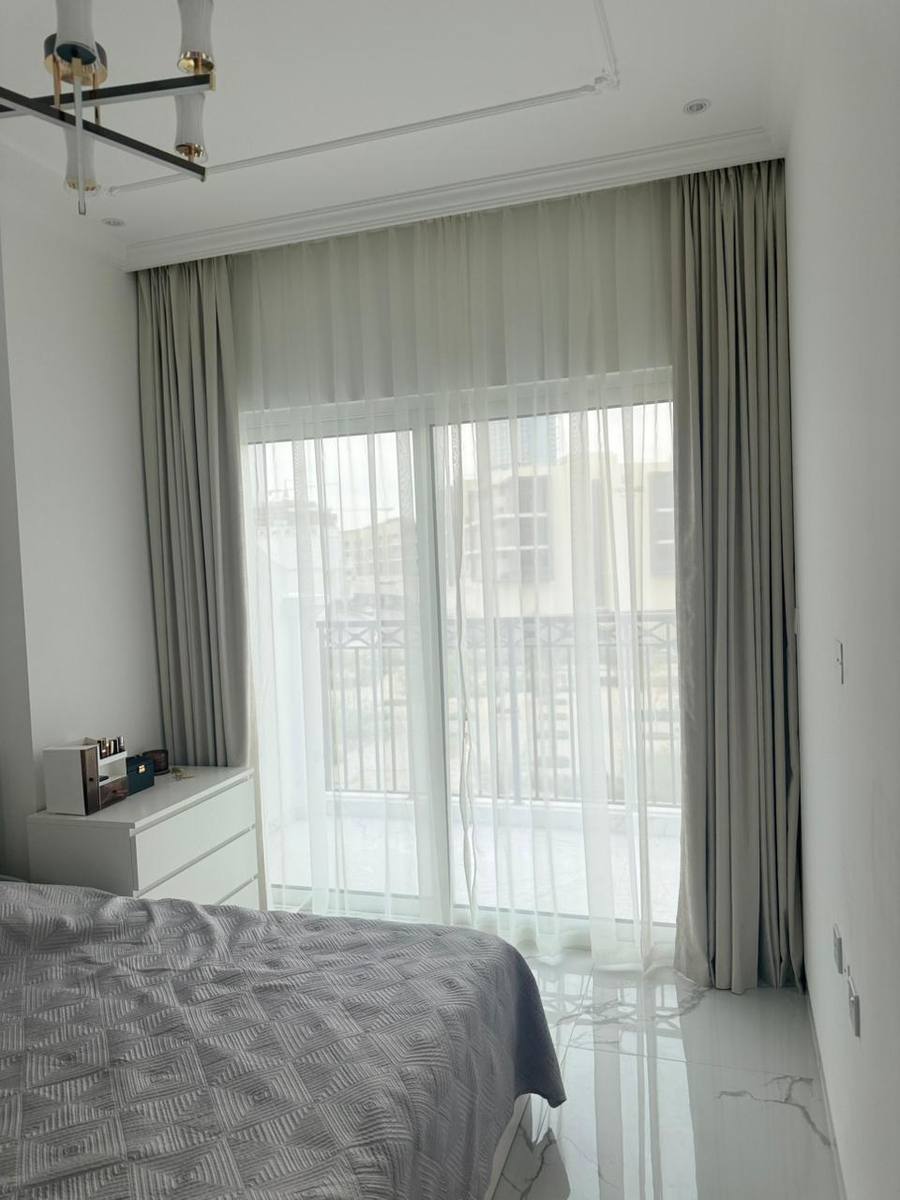 Sheer and grey blackout curtains dressing a bedroom window