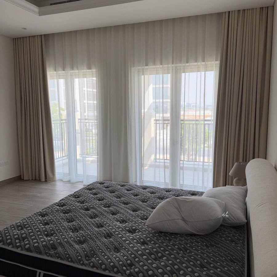 White sheer curtains layered across bright bedroom windows