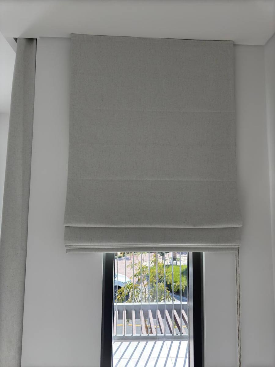Grey roman blind fitted at a balcony door