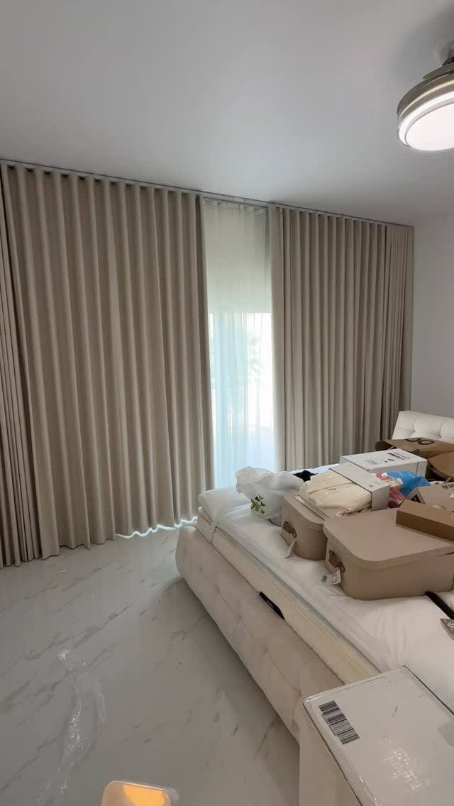 Taupe wave blackout curtains on a ceiling-recessed track in a Meadows villa bedroom