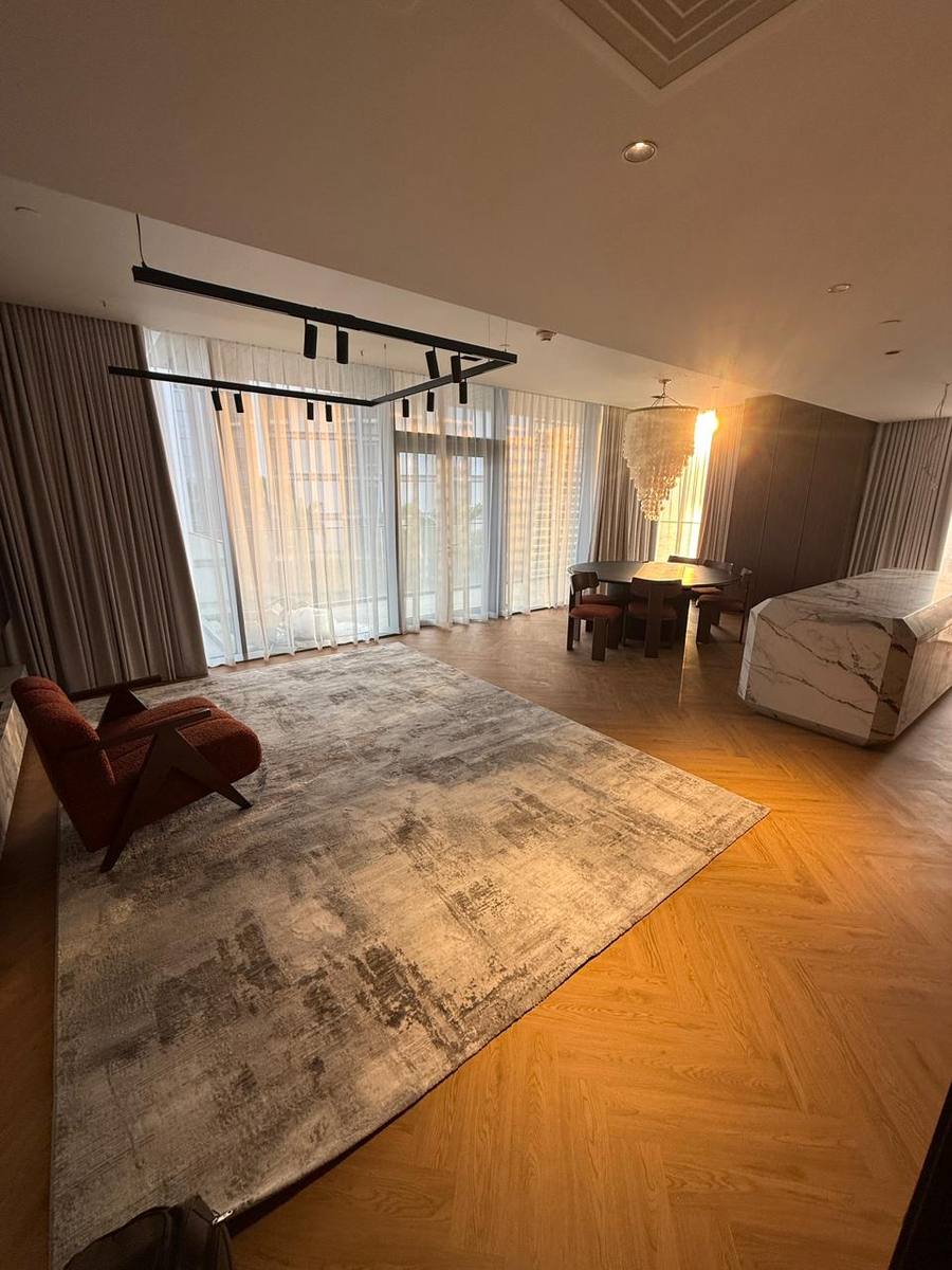 Full-height sheers along the glass wall of an open-plan living room